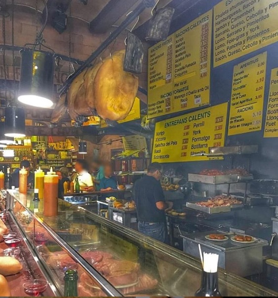 De gele menu borden achter de tapas bar bij Can Paixano 